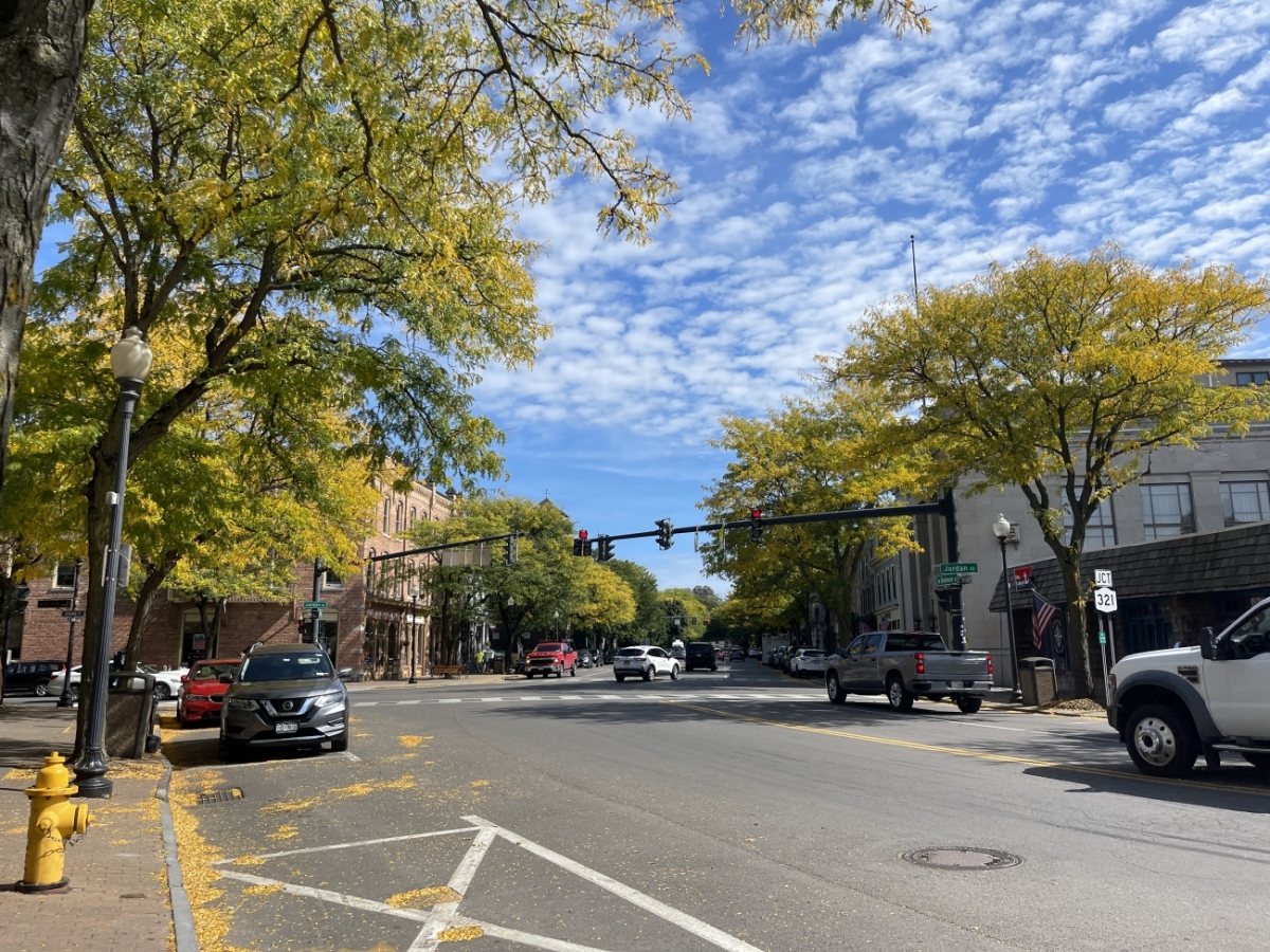 a picture of a street with trees in fall around it